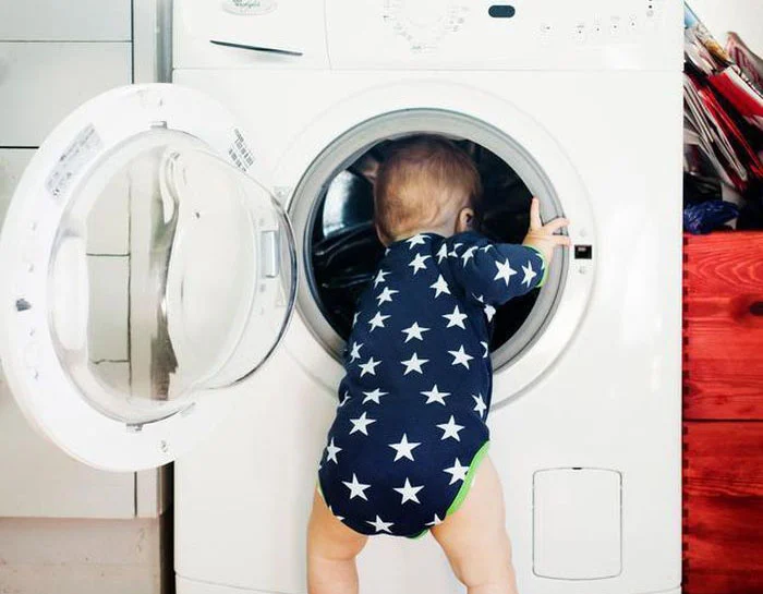 Mở cửa máy giặt trẻ con chui vào máy giặt chơi đùa rất nguy hiểm